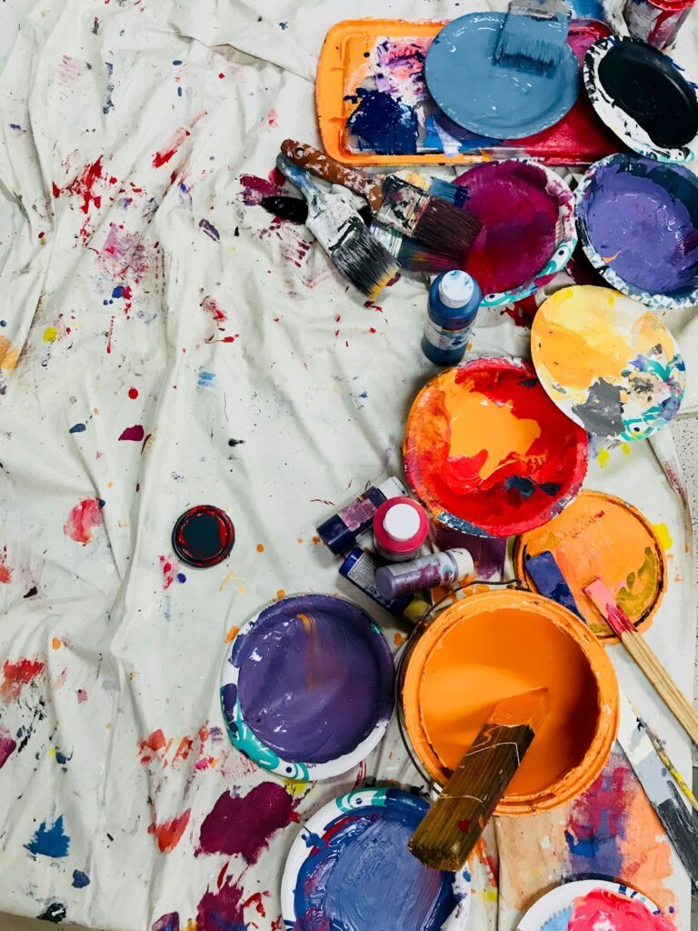 Paint supplies laid out on a drop cloth